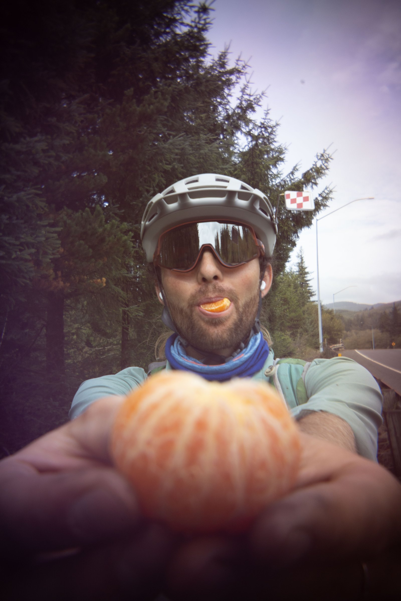 Keane holding up a peeled orange during a roadside snack break
